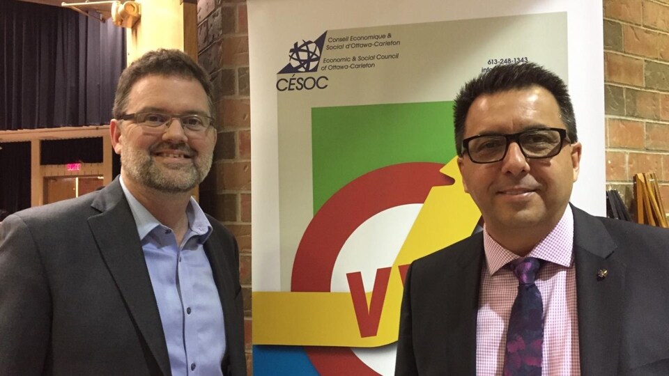 Le maire et le chef de police posent devant une affiche.