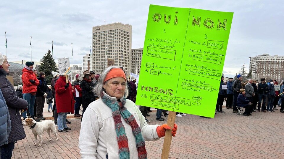 Une femme avec une pancarte à la main. 