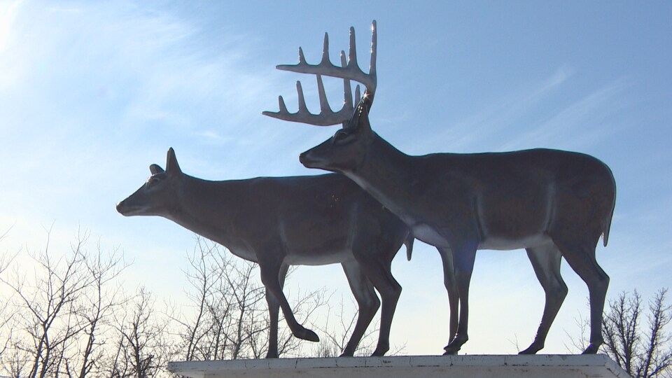Une statue représentant deux chevreuils sur un piédestal.