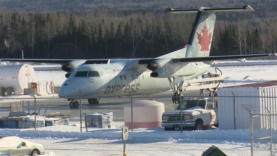 Un avion d'Air Canada Express à un aéroport enneigé.