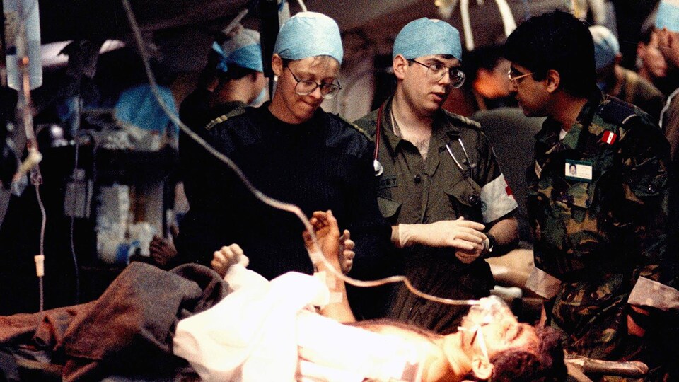 military doctors next to a patient’s bed.