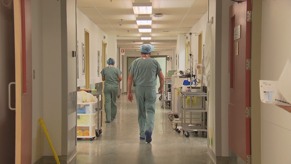 Un médecin  marche dans un corridor d'hôpital