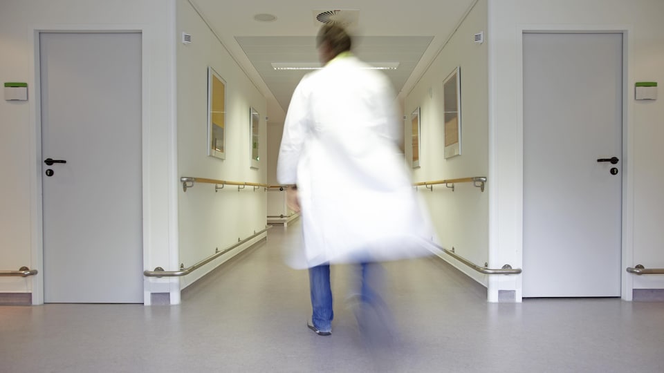 Un médecin marchant dans un hôpital.