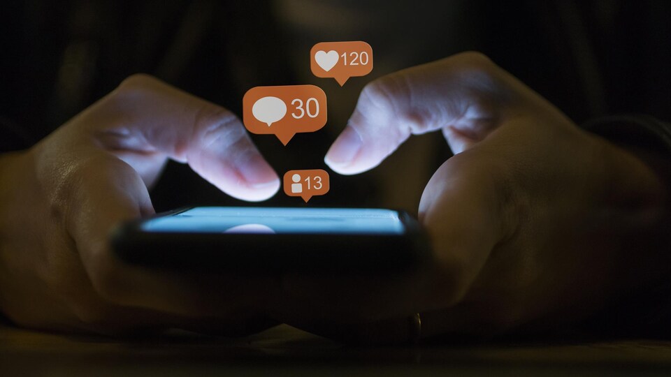 Une jeune fille consulte les médias sociaux sur son téléphone.