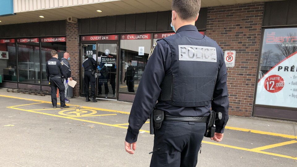 Des agents du SPVQ dans le stationnement du Mega Fitness Gym.