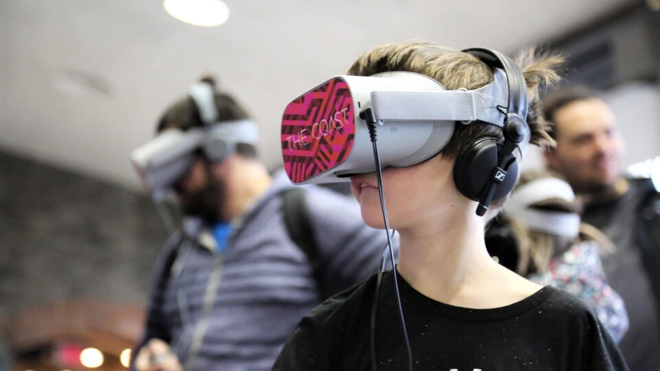 Une personne porte un casque de réalité virtuelle lors d'une exposition.