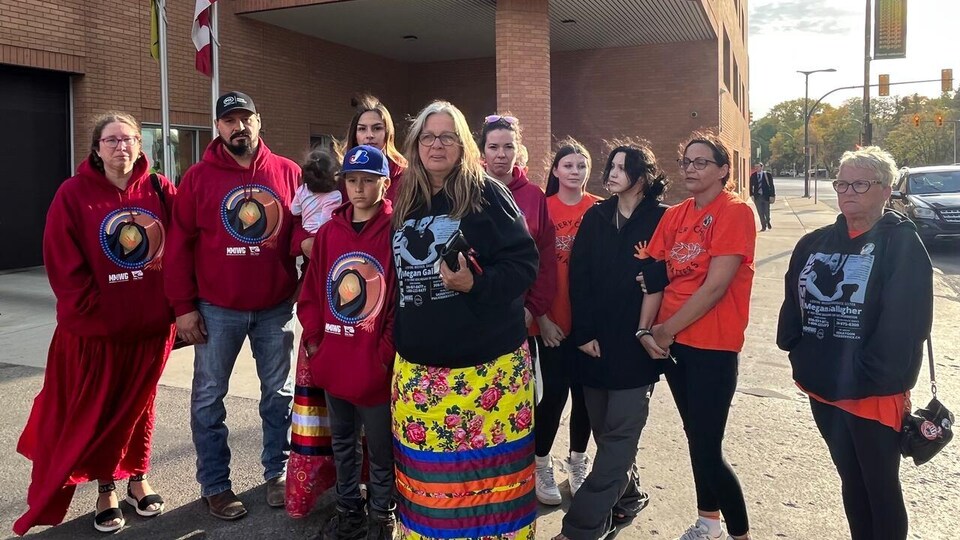Une dizaine de personnes sont rassemblées à l'extérieur de la Cour provinciale, à Saskatoon, le 30 septembre 2022.