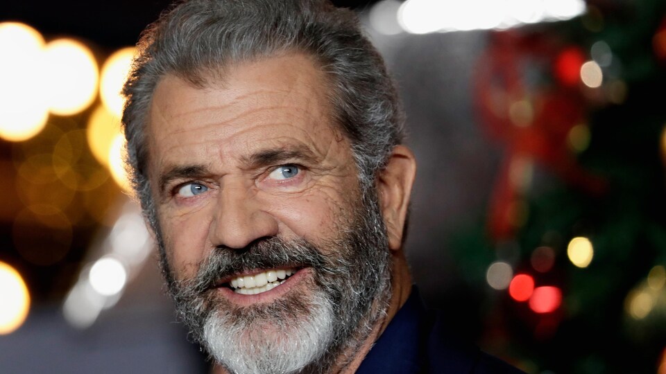 Un homme avec une barbe tout sourire.