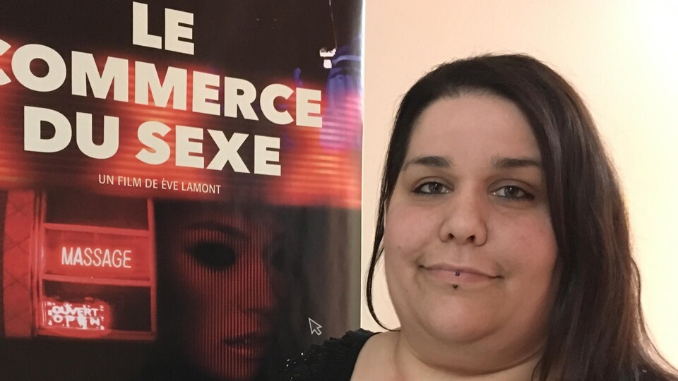 Une femme pose devant une affiche du film «Le commerce du sexe».