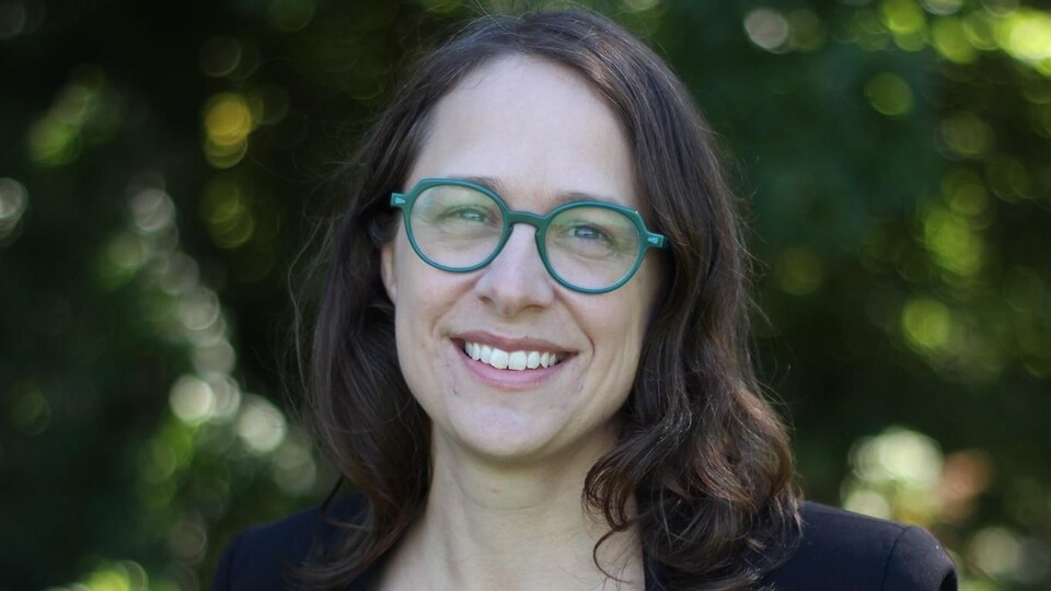 Mélanie Villeneuve sourit. Elle porte des lunettes.