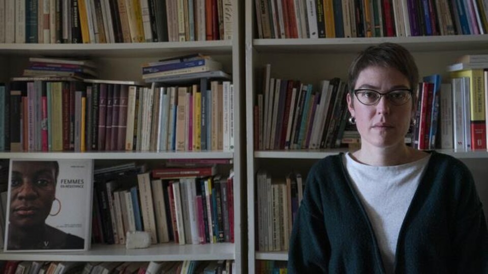 La professeure Mélissa Blais est photographiée devant sa bibliothèque.