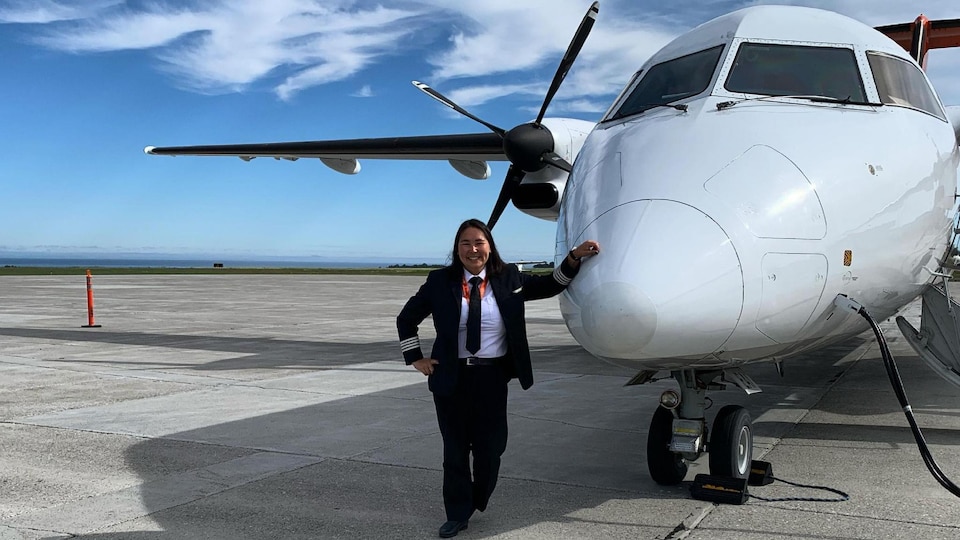 Melissa Haney est sur la piste de décollage à côté de l'avion qu'elle pilote.