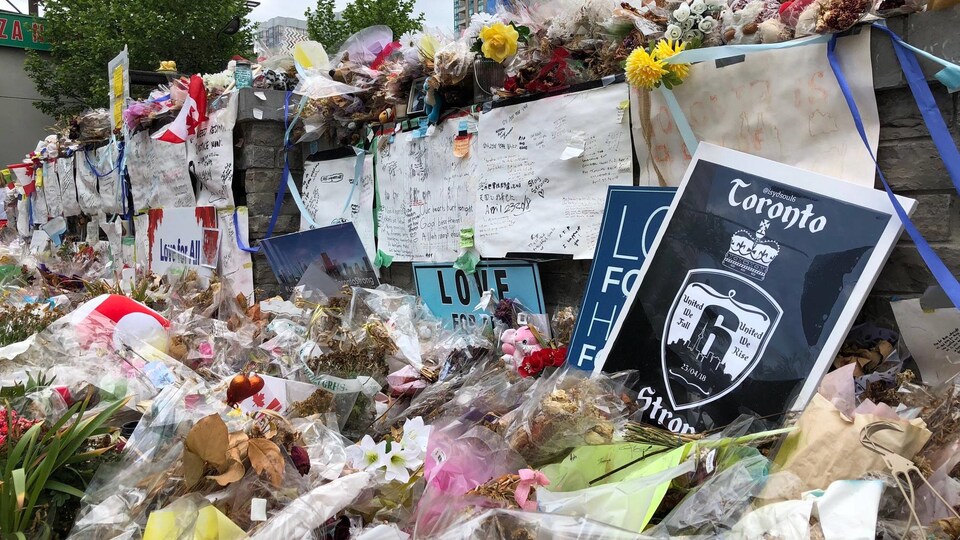 Des fleurs et des affiches sur un mur de briques