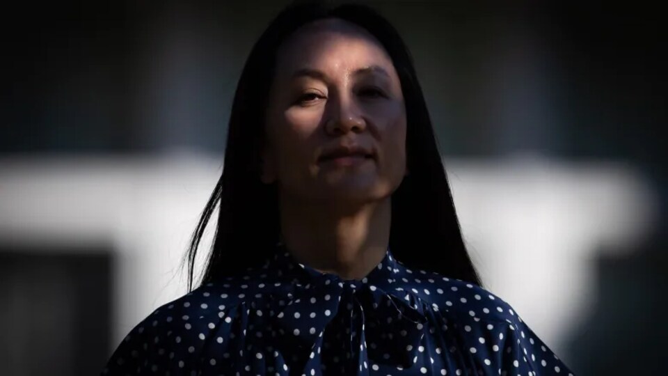 Meng Wanzhou, le visage partiellement couvert par une ombre.