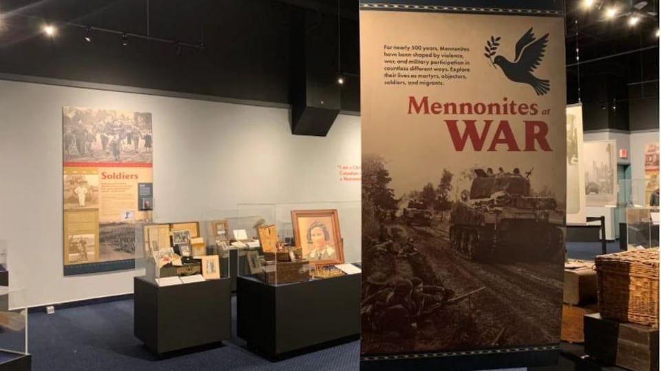 Une salle de musée du Mennonite Heritage Village où on voit des présentoirs et un panneau d'interprétation sur lequel il est écrit « mennonites war » en rouge. 