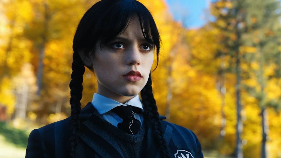 La jeune femme porte de longues tresses noires et est vêtue d'un uniforme d'écolière.