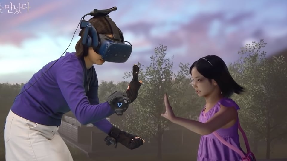 Un mère portant un casque de réalité virtuelle et des gants haptiques tend la main vers une version numérique de sa fille décédée. 