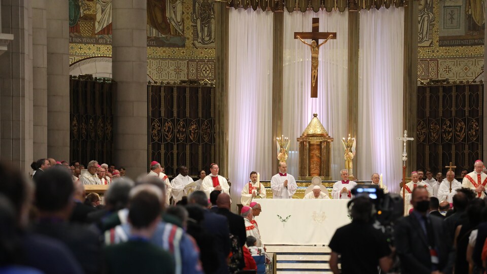 Des fidèles assistent à la messe célébrée par le pape, accompagné d'autres membres de l'Église.
