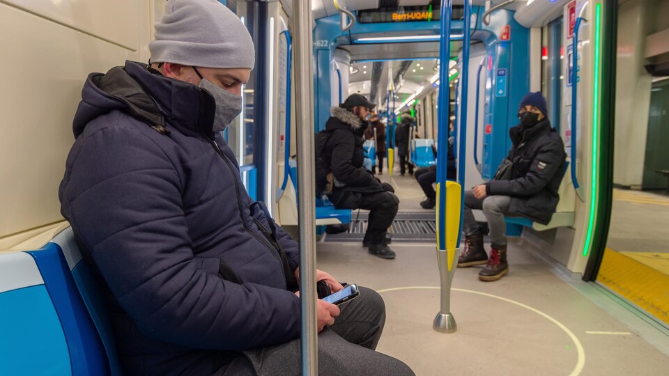 Des passagers assis dans un wagon du métro de Montréal portent le masque.