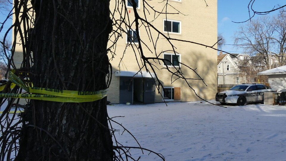 Du ruban jaune de police et une voiture de police.
