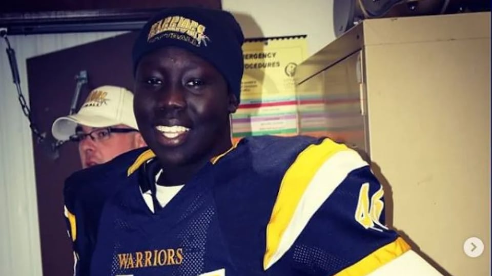 A man allows himself to be photographed, dressed in his football equipment. 