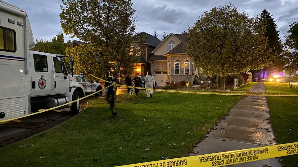 Des enquêteurs de la police devant une scène de crime à Whitby en Ontario.