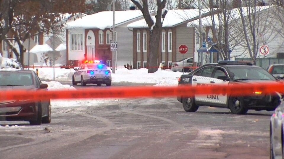 Des voitures de police dans un quartier résidentiel.