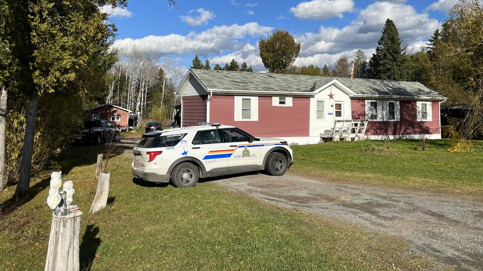 Une voiture de police devant une maison.