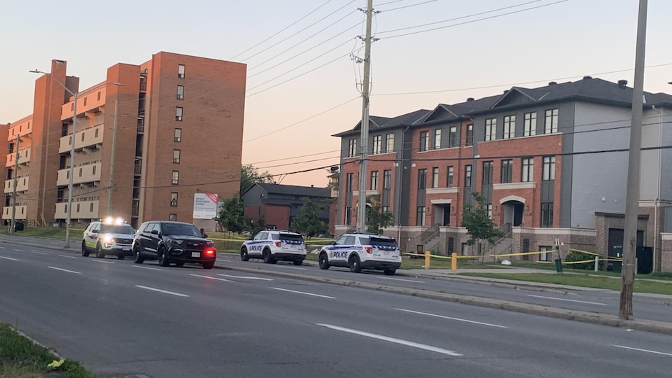 Des voitures de police devant un immeuble.