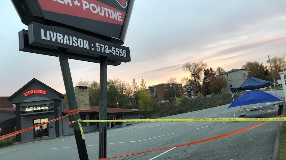 Un stationnement de restaurant avec une partie entourée d'un ruban jaune.