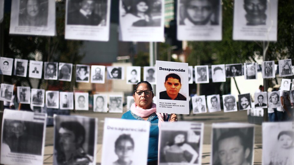 À Mexico, Maria Cristina tient une photo de son fils Manuel, elle et d'autres mères réclament justice pour leur enfant disparu.