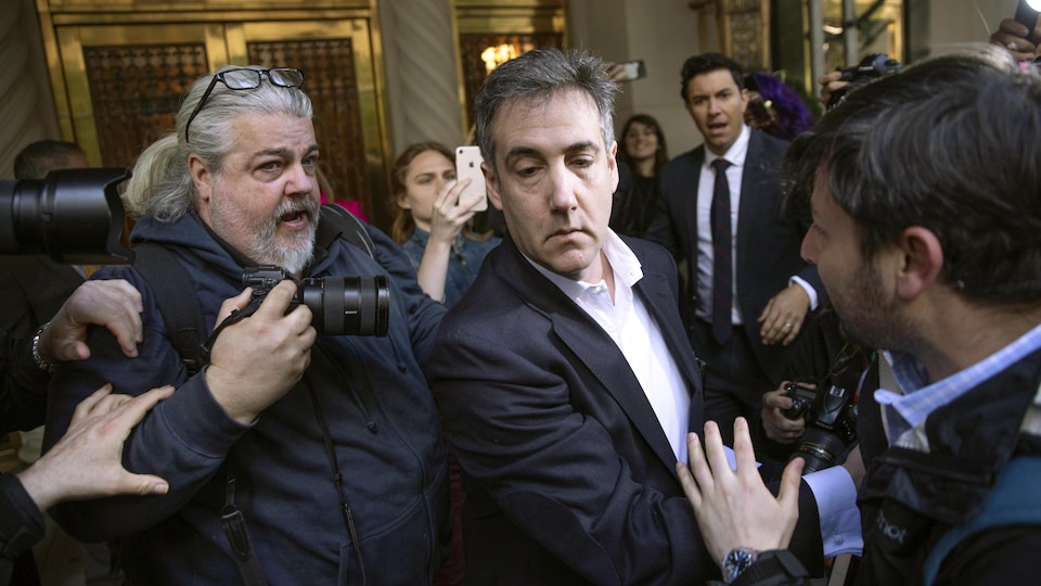Michael Cohen, entouré de journalistes et photographes, quitte son immeuble.