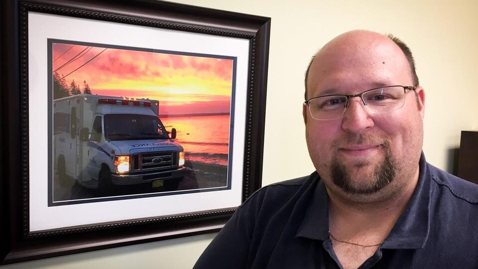 Michael Nickerson devant une photo d'une ambulance.