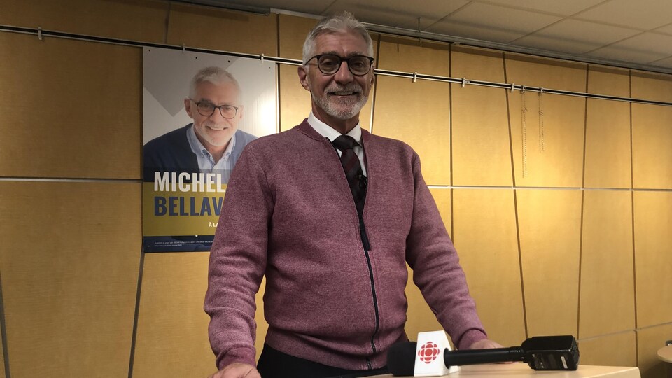 Michel Bellavance photographié derrière un lutrin lors d'une conférence de presse.