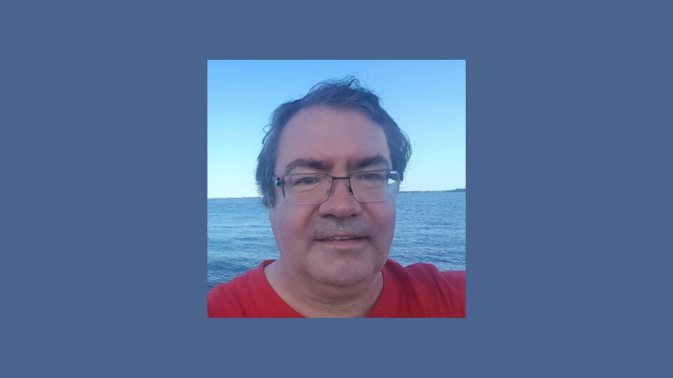 Michel Clément devant un lac.
