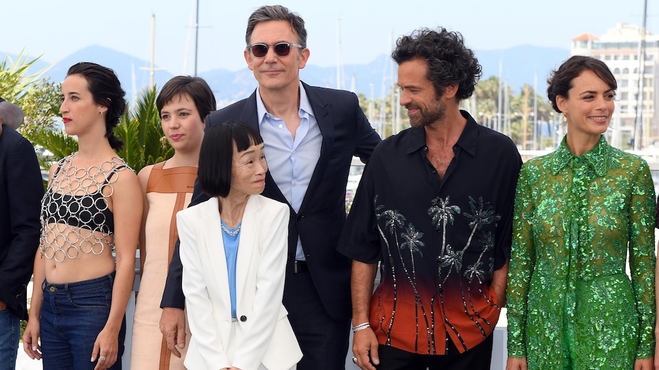 Deux hommes et quatre femmes posent pour les photographes devant le Palais des festivals à Cannes. 