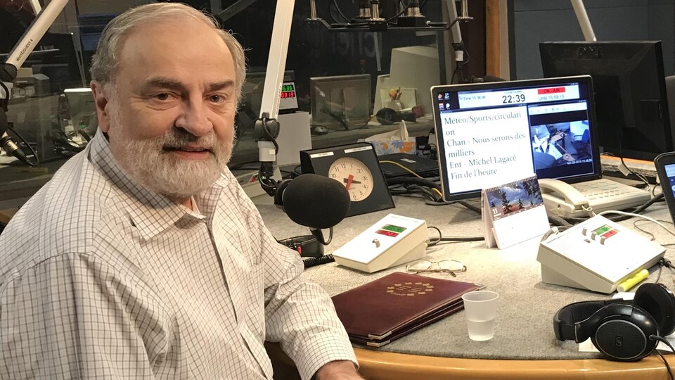 Michel Lagacé assit près d'un micro dans le studio de radio.