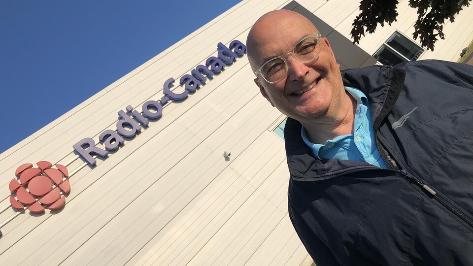 Michel Nogue devant la station de Radio-Canada Acadie.