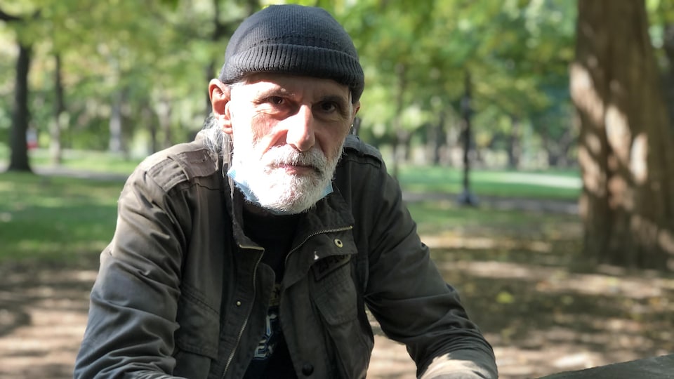 Michel Sénécal, assis à une table de pique-nique dans un parc.
