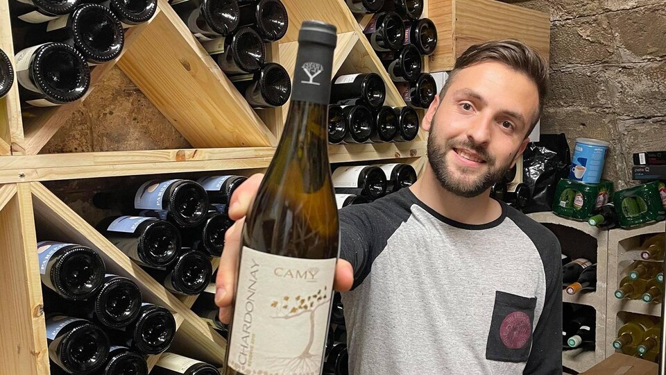 Mickaël Larrive tient une bouteille.