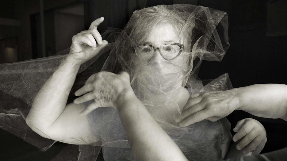 Une dame avec des lunettes se fait envelopper dans du tissu.
