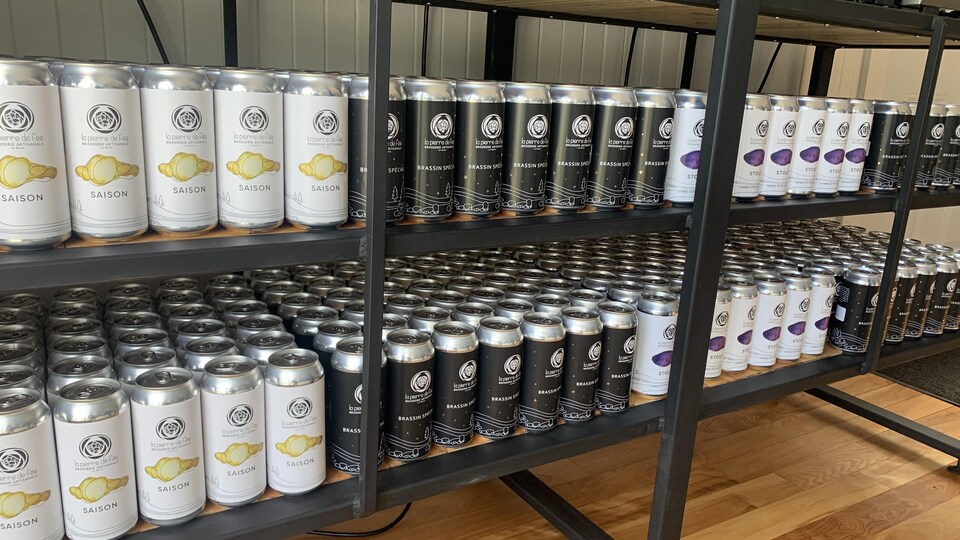 Des cannettes de bière sur des tablettes.