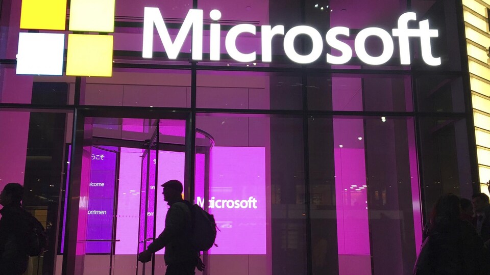 Des personnes passent devant un bureau de Microsoft à New York. 