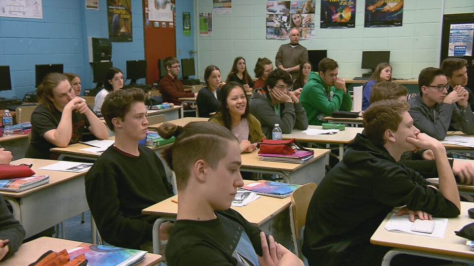 Des élèves du secondaire à l'intérieur d'une classe d'école