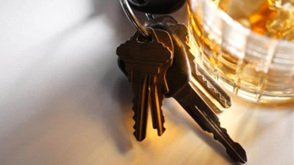 Un verre d'alcool sur une table avec un trousseau de clés.