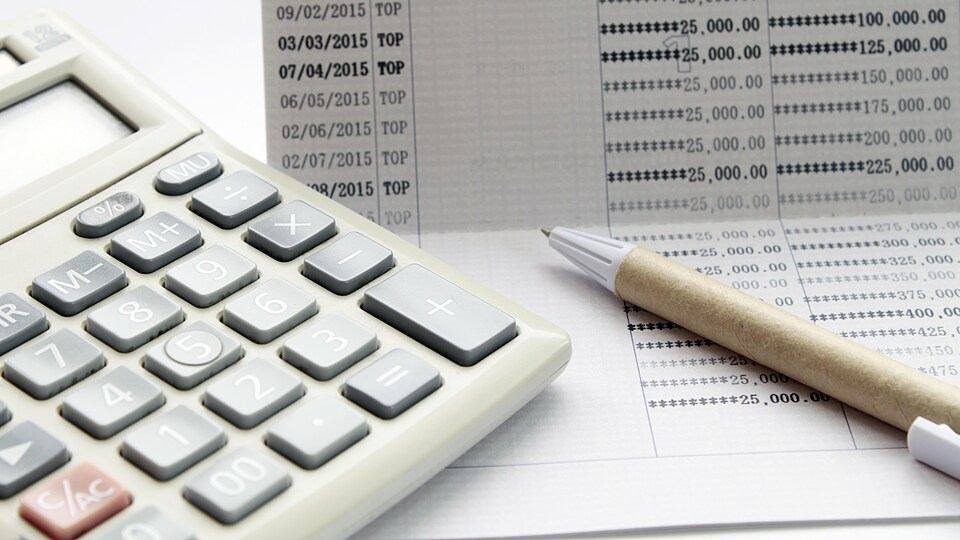Un carnet de banque, un stylo et une calculatrice
