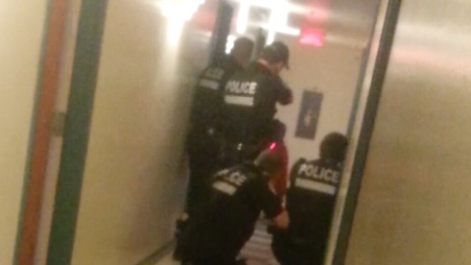 Des policiers du SPVM dans un couloir lors d'une opération visant à maîtriser Pierre Coriolan.