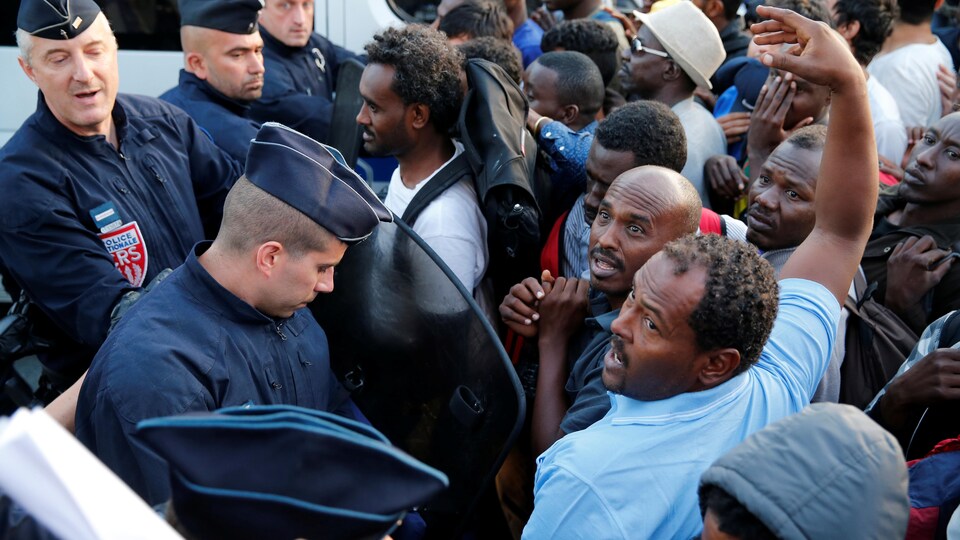 Des policiers français bloquent le passage des migrants qui occupaient le camp improvisé de la porte de la Chapelle.