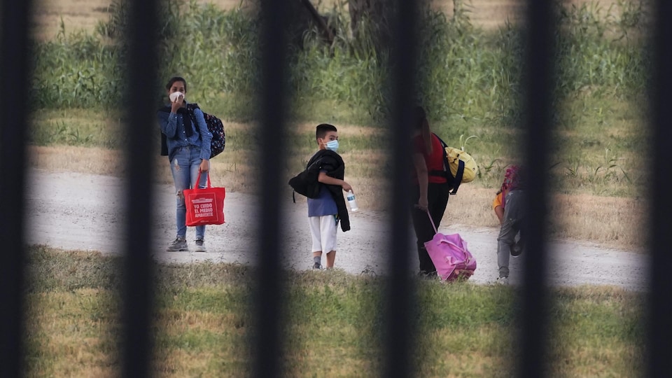 Des migrants à Del Rio, au Texas, photographiés derrière une barrière de sécurité.