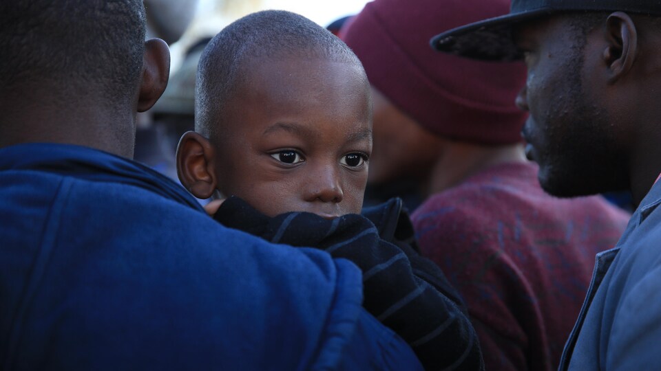 Photo d'un enfant haïtien dans les bras de son père